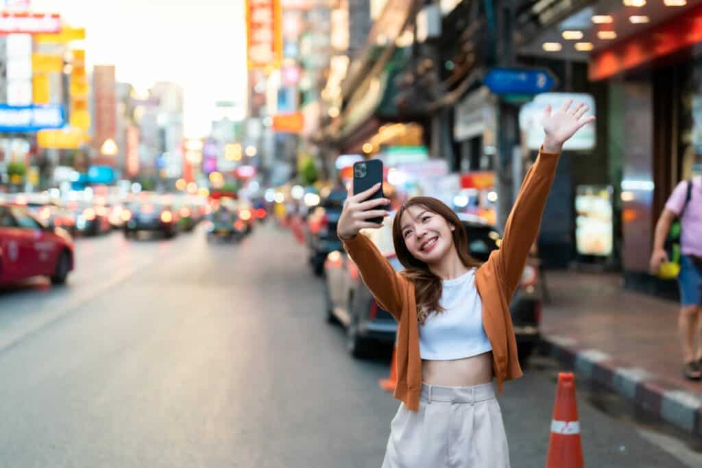 chinese influencer taking salfie in a busy city in china